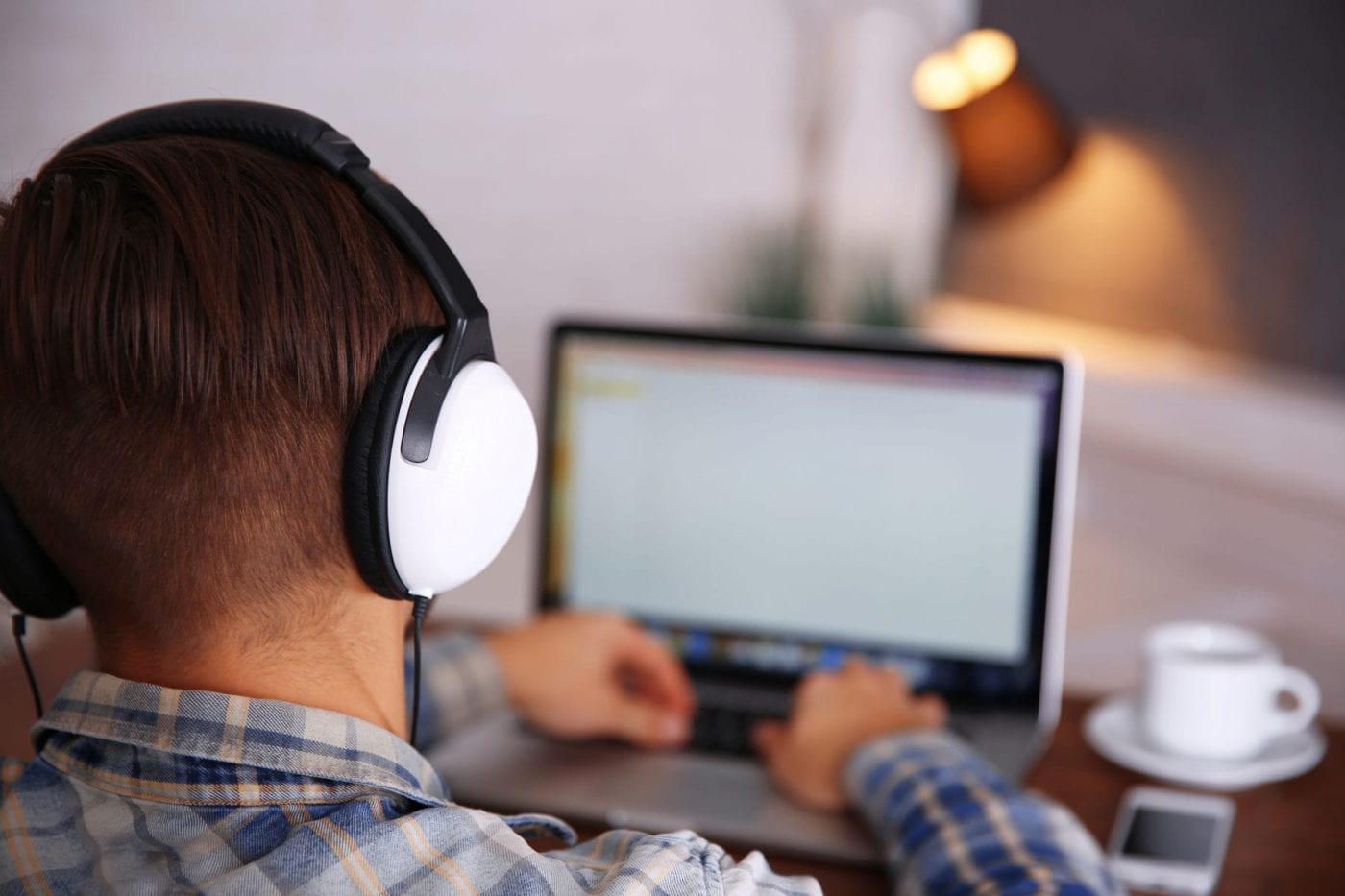 person wearing headphones working on a laptop