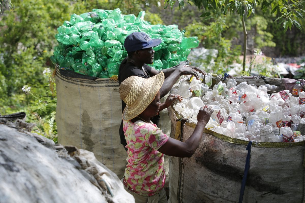 two people segregating plastic bottles