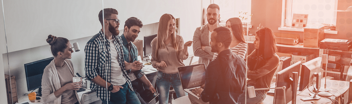 group of people close together in an office talking